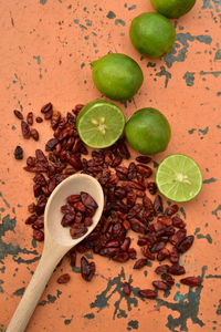 Cool green limes hot red dried chili peppers on tabletop