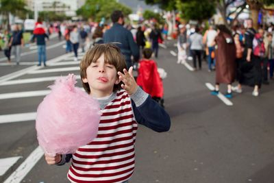 Boy standing on road in city