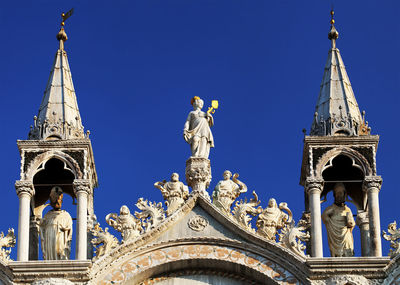 Statues and carvings on saint mark basilica against clear blue sky