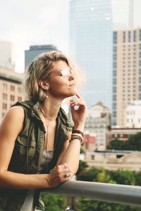 Beautiful young woman in city against sky