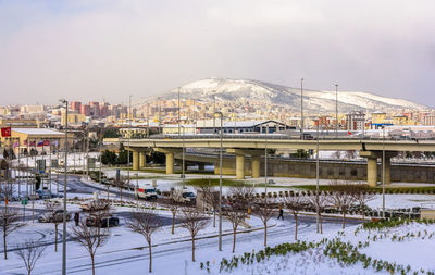 Bridge by buildings against sky during winter