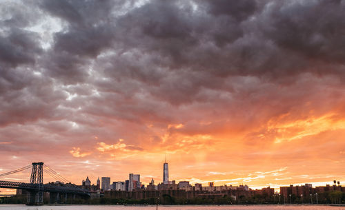 Scenic view of dramatic sky over city during sunset