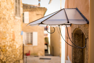 Close-up of illuminated lamp against building