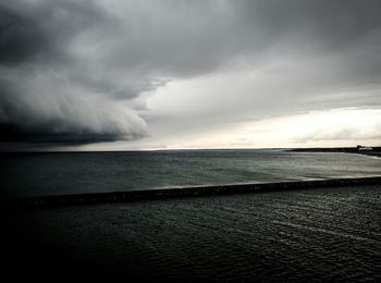 Scenic view of sea against cloudy sky