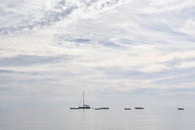 Boats sailing on sea against sky