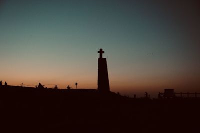 Lighthouse against clear sky during sunset