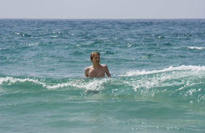 Smiling man in sea against sky