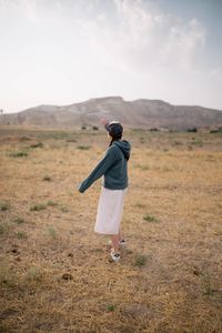 Rear view of woman standing on field