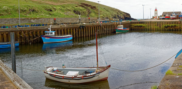 Boats moored at shore against sky