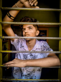 Portrait of young man standing against wall