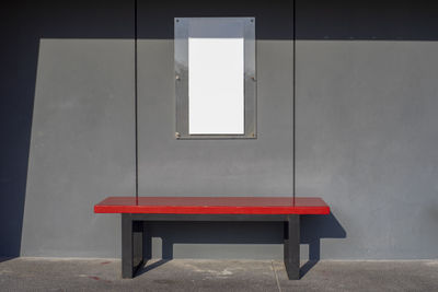 Empty bench on table against wall