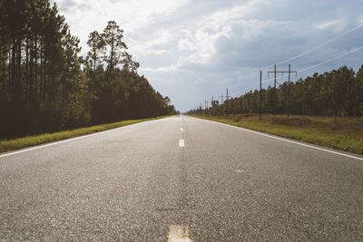 Road amidst trees against sky