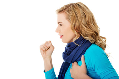 Woman coughing against white background