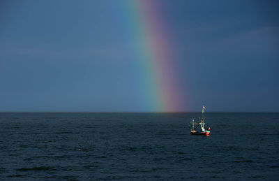 Scenic view of rainbow over sea against sky