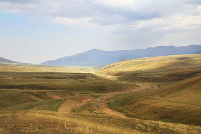 Wide steppe with a river and a distant view of the mountain ranges on the assy plateau in autumn