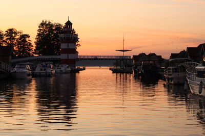 Boats in sea at sunset