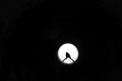 Silhouette man standing in tunnel