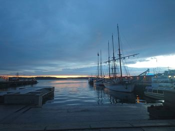 Boats moored at harbor against sky at night