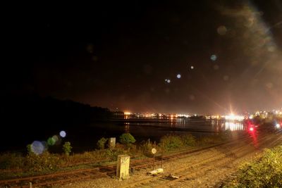 Illuminated bridge against sky at night