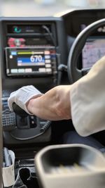 Cropped hand of man driving car