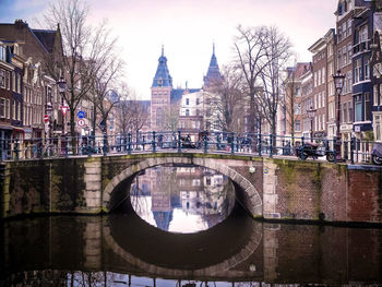 Bridge over canal amidst buildings in city