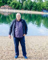 Portrait of man standing by lake