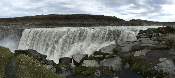 Scenic view of waterfall against sky