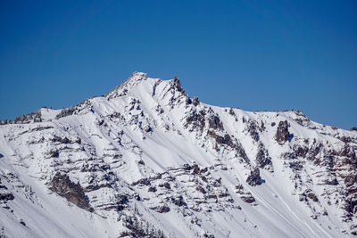 Scenic view of snowcapped mountains against clear blue sky