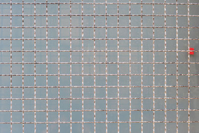 Metal grid on a concrete block background