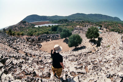 Rear view of man on landscape against clear sky