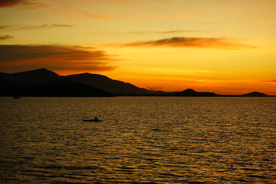 Scenic view of sea against orange sky