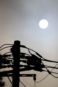 Low angle view of silhouette rollercoaster against sky at sunset