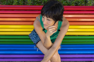 Man sitting on multi colored bench