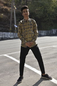 Portrait of young man standing on road