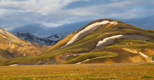 Scenic view of field and mountains against sky