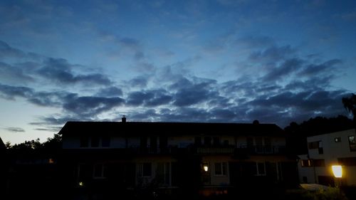 Low angle view of houses against cloudy sky