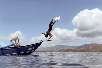 Man jumping from boat into sea