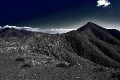 Scenic view of snowcapped mountain against cloudy sky