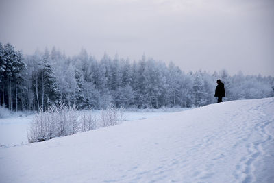 Man on snow covered landscape against sky