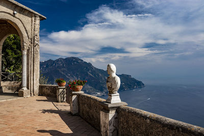 Statue in sea against cloudy sky