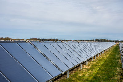 Solar panels on field against sky