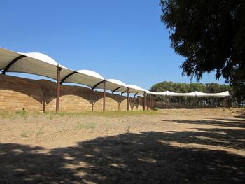 Built structure on field against clear sky on sunny day