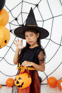 Low angle view of girl standing by pumpkin