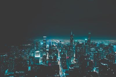 Illuminated cityscape against sky at night