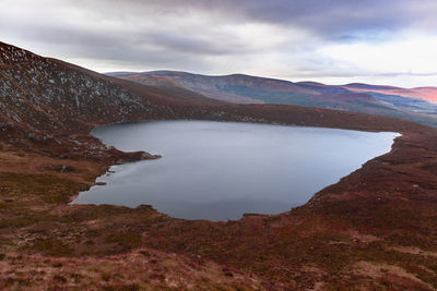 Scenic view of lake by mountains against sky