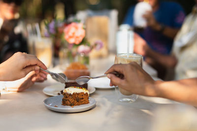 Midsection of woman eating slice of cake