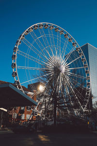 Low angle view of ferris wheel against blue sky