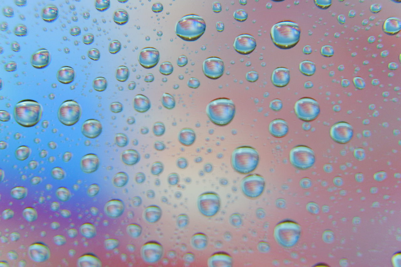 FULL FRAME SHOT OF WET GLASS WITH RAINDROPS