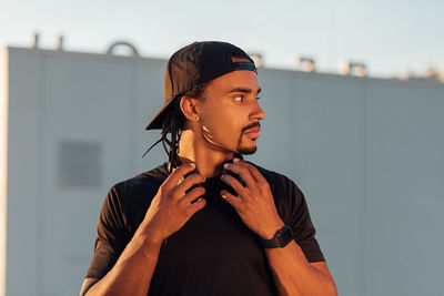 Portrait of young man standing against wall