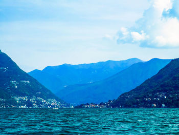 Scenic view of sea and mountains against sky